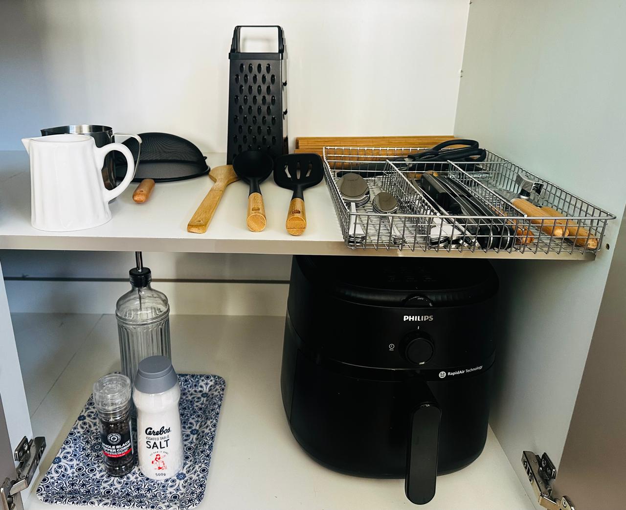 Kitchen cupboard with utensils and air fryer