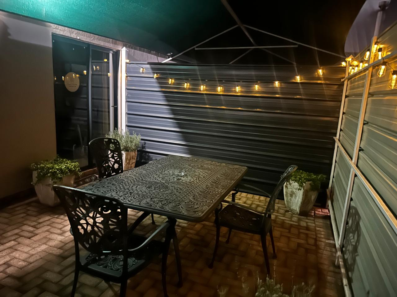 Private patio at night with warm string lights